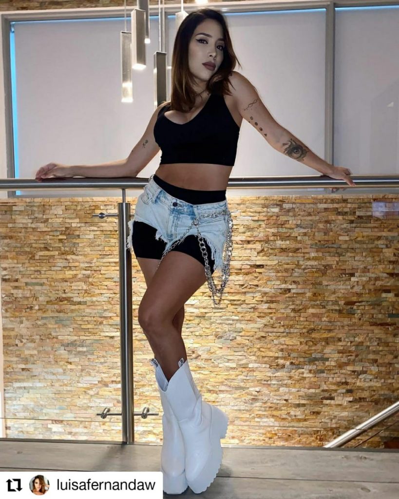 foto de mujer usando top negro short de jean y botas blancas