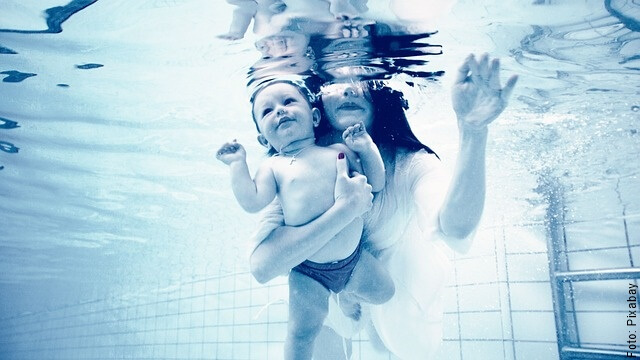 foto de mujer nadando con un bebé