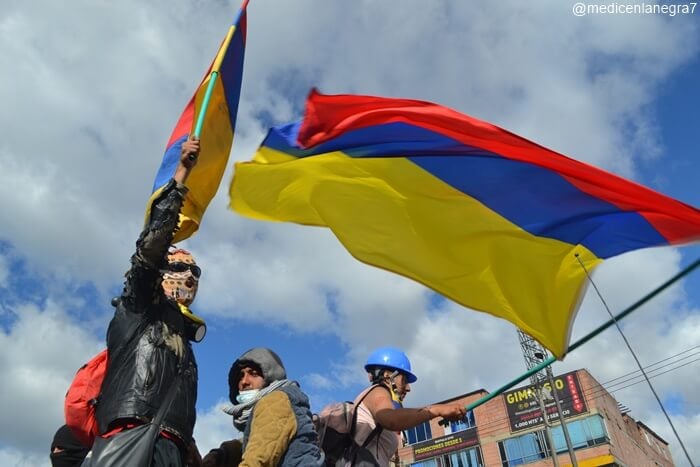 Foto manifestantes sosteniendo la bandera de Colombia al revés