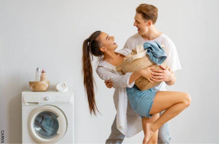 Foto de una pareja abrazados junto a una lavadora