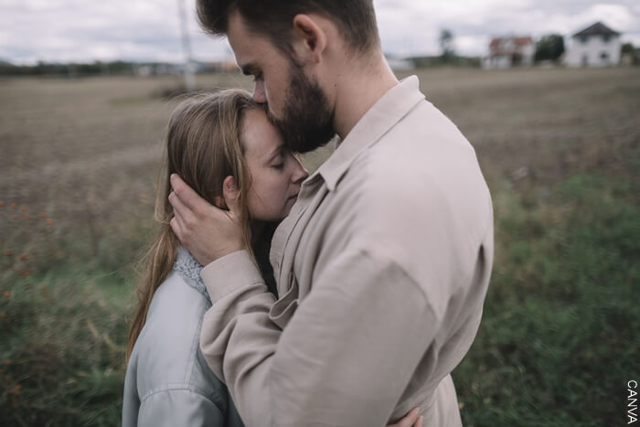 Hombre dando un beso en la frente a una mujer