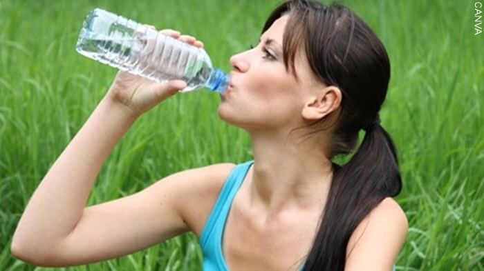 Imagen de mujer tomando agua para ilustrar como Desaparece las estrías de tu busto de forma natural