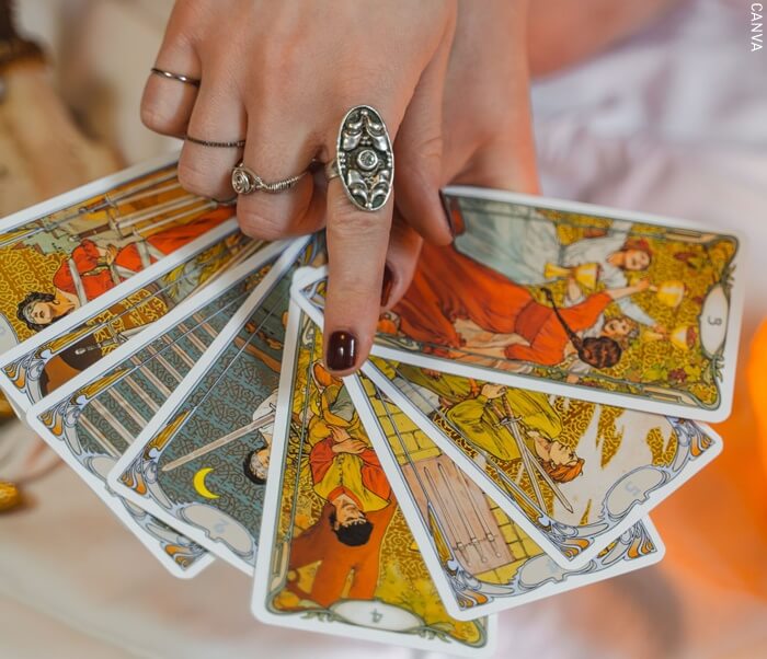 Fotografía manos de mujer mostrando cartas del tarot