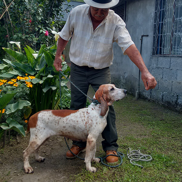 Foto de un campesino junto a su perro cazador