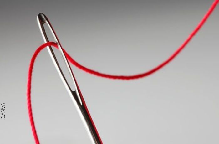 Foto de una aguja con hilo rojo