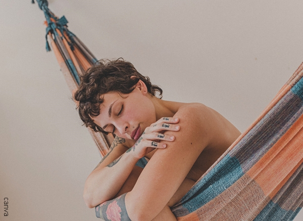 Foto mujer dormida en una hamaca sin ropa.
