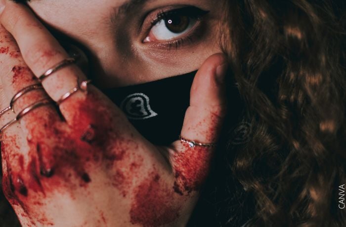 Foto de una mujer con una mano lastimada y con sangre