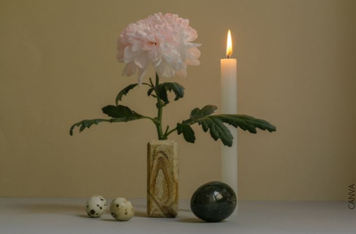 Foto de una vela junto a una flor