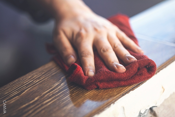 Foto de mano limpiando con un trapo rojo.