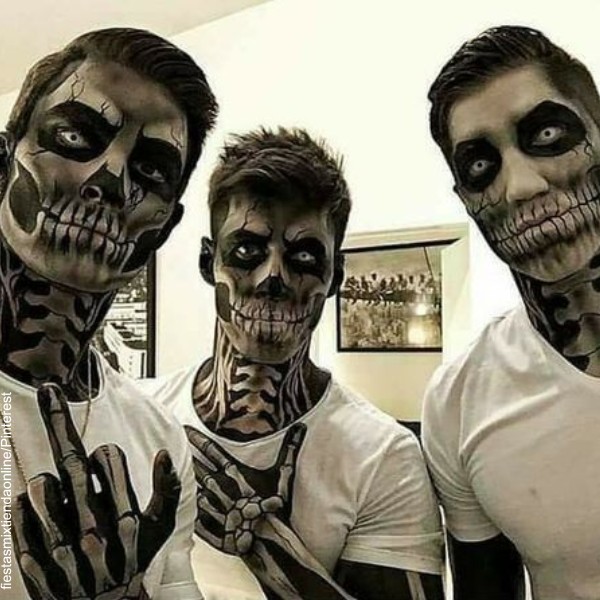 Foto de 3 hombres maquillados como calaveras.