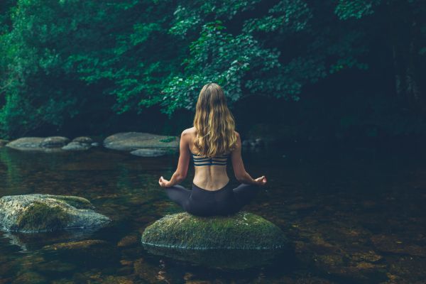 Foto de mujer meditando en la naturaleza.