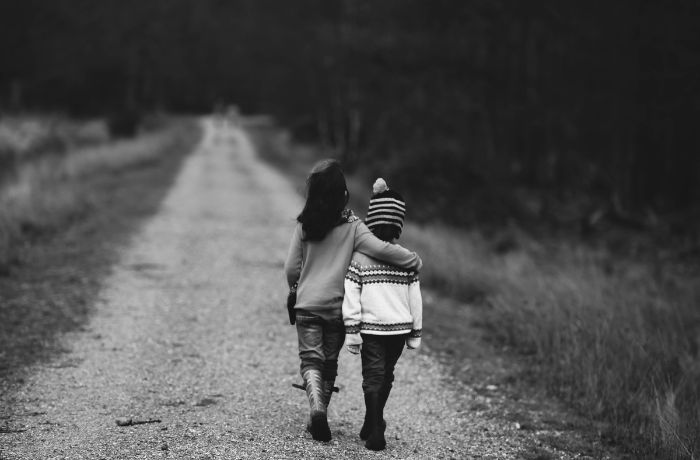 Dos niños caminando abrazados reforzando su amistad
