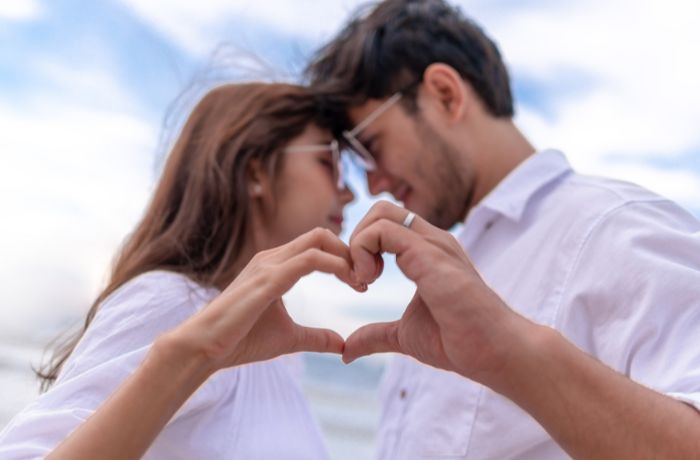 Foto de una pareja haciendo un corazón con las manos y pegados de la frente