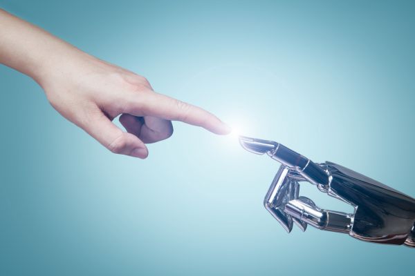 Una mano de una persona con una mano de un robot
