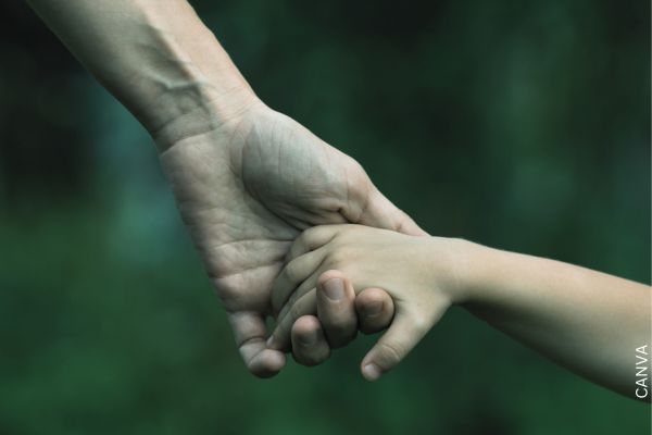 Foto de una mano de hombre y una de niño entrelazada