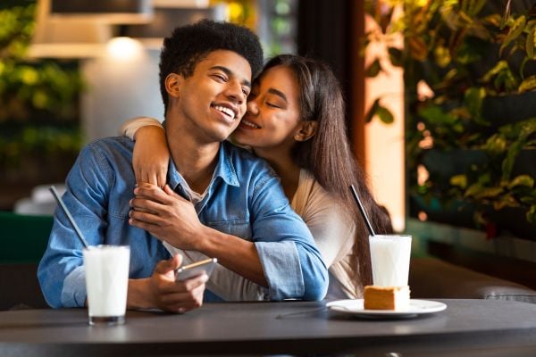 Pareja en un restaurante. Mujer abrazando a hombre