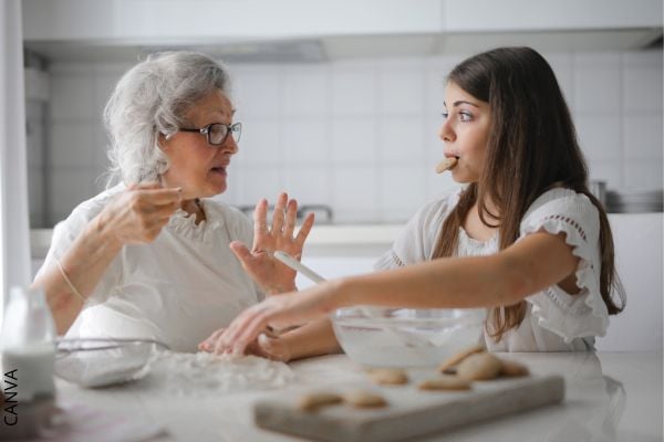 Foto de abuela hablando con una mujer en la cocina.