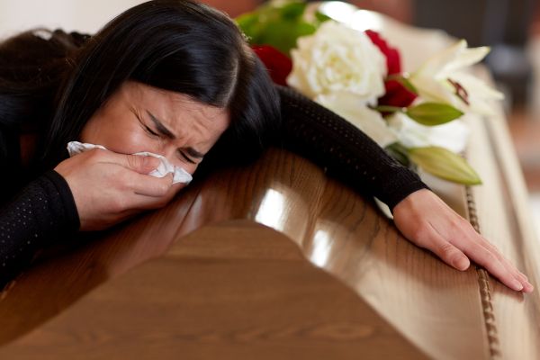 Mujer llorando sobre un ataúd
