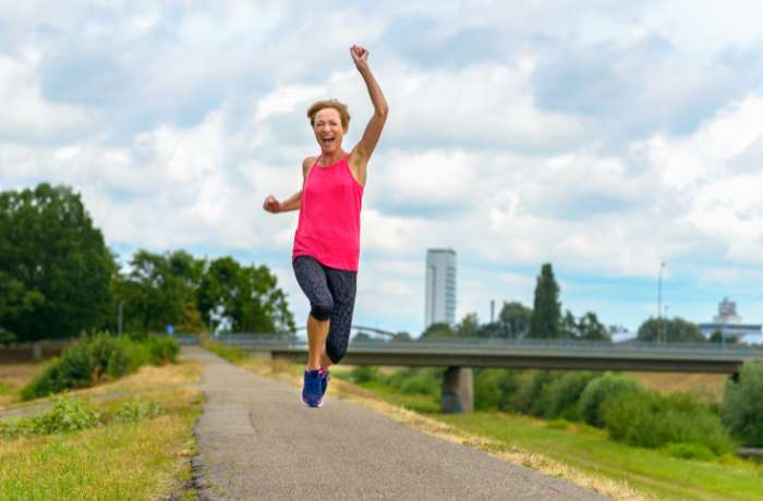 Foto de mujer con ropa deportiva feliz y saltando