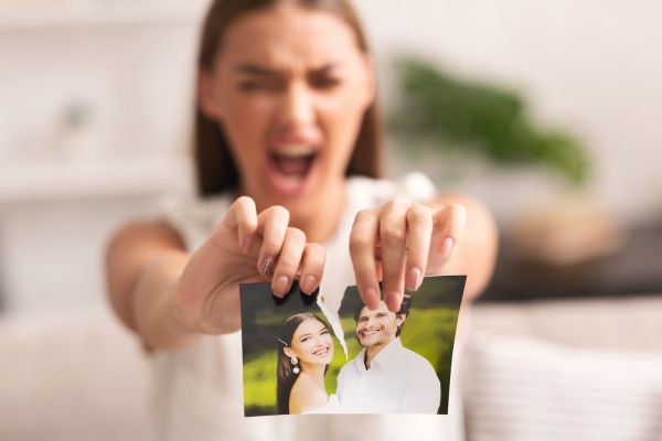 Mujer rompiendo foto de una pareja